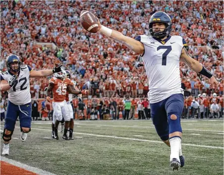 ?? Nick Wagner / Associated Press ?? West Virginia quarterbac­k Will Grier scores the game-winning two-point conversion in the final seconds against UT on Saturday.