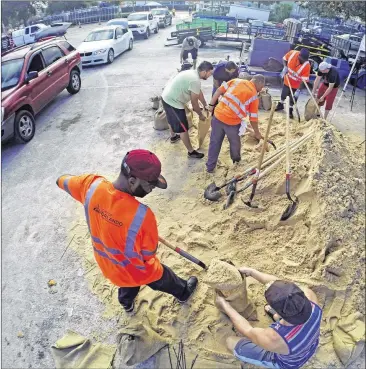  ?? RED HUBER / ORLANDO SENTINEL VIA AP ?? Residents fill up sandbags Thursday in Orlando, Fla., as they prepare for Hurricane Irma. Long lines of vehicles waited for hours to get a 10-sandbag limit at the City of Orlando Public Works facility.