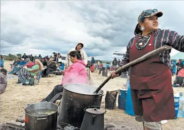 ?? WILLIAM YARDLEY/LOS ANGELES TIMES ?? Nantinki Young, right, of the Rosebud Sioux from South Dakota, runs the cook shack at a pipeline protest in North Dakota.