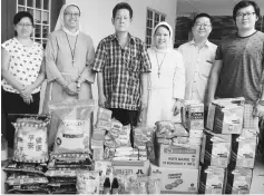  ??  ?? Lim (third left) and Sister Emelda (third right) during the delivery of aid items.