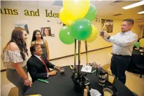  ?? LUIS SÁNCHEZ SATURNO/THE NEW MEXICAN ?? Vernon Muller, right, takes a picture Wednesday of his daughter Cassaundra Muller, 17, left, and her running teammate Brittaney Martinez, 17, with Olympic gold medalist Billy Mills at the Pecos High School athletic banquet.