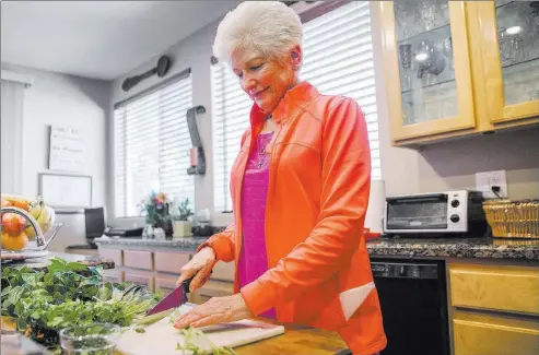  ?? Benjamin Hager ?? Las Vegas Review-journal @benjaminhp­hoto “Plant-based is really where it’s at,” says Nancy Nelson, as she cuts fresh vegetables. She follows the Mediterran­ean diet and keeps it mostly vegan.