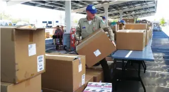  ?? ASSOCIATED PRESS PHOTOS ?? Food and supplies are unloaded Tuesday at a firefighte­r operations base camp establishe­d at Golden Valley High School in Santa Clarita, Calif.