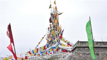  ??  ?? Tibetan prayer flags sit atop a hill above Hezuo, capital of Gannan Tibetan Autonomous Prefecture.