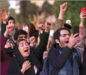  ??  ?? DISSENT: An angry crowd in Tehran shout slogans against the government yesterday as they confront police officers armed with tear gas and water cannon