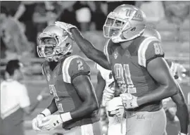  ?? Luis Sinco Los Angeles Times ?? JORDAN LASLEY (2) is congratula­ted by fellow receiver Caleb Wilson after a touchdown against Texas A&M. Both average more than 100 yards a game.