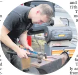  ?? JONATHAN PORTER ?? A farrier making horseshoes
at the fair