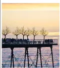  ??  ?? People socialisin­g on Aberystwyt­h pier as the sun sets on an isolated warm day