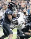  ?? JOHN MINCHILLO/AP ?? Cincinnati linebacker Jarell White, left, intercepts a UCF pass in the second half of a 2019 game.