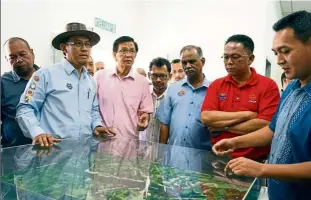  ??  ?? Md Jais (wearing hat) being briefed on the progress of the RM100mil Kahang Dam project on March 20.