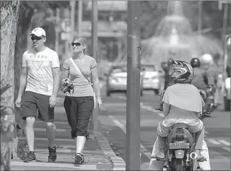  ?? AHMAD KHUSAINI/JAWA POS ?? ASYIK MELENGGANG: Pasangan WNA sedang berjalan-jalan di jalur pedestrian.