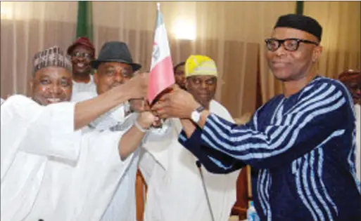  ??  ?? L-R: Vice-President Namadi Sambo and Secondus handing the PDP flag to the Ondo State Governor, Olusegun Mimiko, when the latter defected to PDP