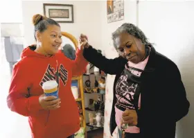  ??  ?? Aitulagi Evans (left) and Betty Brown, who have lived in the neighborho­od for 35 years, enjoy Brown’s new home at Hunters View.