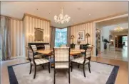  ?? ?? Highlights of the formal dining room include a Murano chandelier and frameless corner windows.