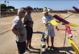  ?? Harbor Soaring Society ?? CHRIS ADAMCYZK, right, holds his glider at the model airplane flying field at Costa Mesa’s Fairview Park in 2019. The field has been closed for over a year.