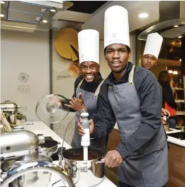  ?? COOKING UP A STORM. Linda Mntambo and Ayanda Nkosi with Brilliant Khuzwayo in the background. ??
