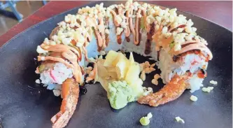  ?? ?? The Knoxville roll at Lim Dynasty Asia Cafe includes shrimp tempura, cream cheese and crawfish meat. It’s topped with snow crab, sliced avocado and two kinds of sauces.