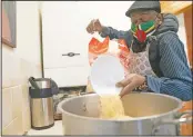  ?? (AP Photo/Jon Super) ?? Volunteer Dave Williams pours in rice to cook as members of the Preston Windrush Covid Response team prepare West Indian meals at the Xaverian Sanctuary, in Preston, England.