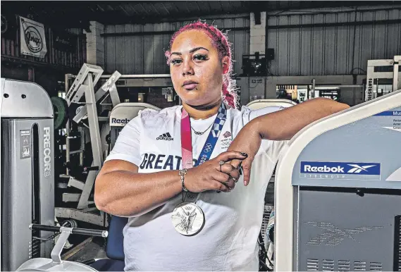  ?? ?? Precious metal: Emily Campbell at her gym in Alfreton, wearing the Olympic medal – the first gained by a British woman in weightlift­ing – that she won at the Tokyo Games (below)