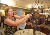  ?? Dan Watson/The Signal ?? Tracy Smith ties a ribbon on the “tree of recovery” for her son Wednesday during the Voices of Recovery panel discussion, held at the Dianne G. Van Hook University Center on the COC Valencia campus.