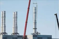  ?? DAVE JOHNSON THE WELLAND TRIBUNE ?? A worker watches as a stack is put into place at GE's Welland Brilliant Factory this week.