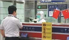  ?? CHINA DAILY PROVIDED TO ?? Xiao Hong checks the entry documents of a member of a flight crew at the Beijing Capital Internatio­nal Airport in September.