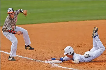  ?? STAFF PHOTO BY DOUG STRICKLAND ?? Ringgold’s Wyatt Tennant slides into third base on a wild throw to Hart County third baseman Will Dean during the opening game of a second-round series in the GHSA Class AAA state playoffs Wednesday in Ringgold, Ga. Ringgold won 5-4. The series continues today.