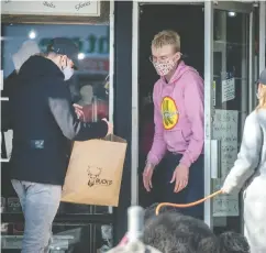  ?? PETER J. THOMPSON / FINANCIAL POST FILES ?? Shoppers and staff wearing masks do curbside shopping business in Toronto in early March, before COVID third-wave restrictio­ns came into force.