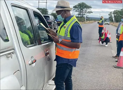  ??  ?? Pic: Min Mhona via Twitter
Transport minister Felix Tapiwa Mhona chats with a motorist and giving him children’s handbooks at a roadblock in Nkayi yesterday. Mhona was in the company of officials from the Traffic Safety Council of Zimbabwe and the Automobile Associatio­n of Zimbabwe.