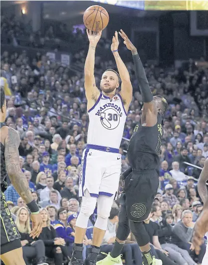  ??  ?? Warriors guard Stephen Curry shoots during the match against the Hawks.