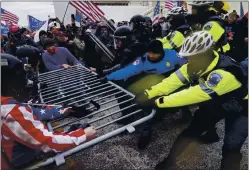  ?? JOHN MINCHILLO — THE ASSOCIATED PRESS ?? Trump supporters try to break through a police barrier Wednesday at the Capitol.