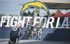  ?? Robert Gauthier Los Angeles Times ?? SERGIO RUIZ of Oxnard photograph­s his children, from left, Sergio Jr., Diego and Christian at StubHub Center, where the Chargers and Rams held a workout.