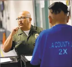  ??  ?? SHERIFF’S custody assistant Rodolfo Cabrera, left, handles the paperwork for an inmate at the Men’s Central Jail in Los Angeles.