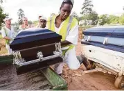  ?? Elizabeth Conley / Houston Chronicle ?? Prisoners move the casket carrying the remains of Jack Harry Smith, Texas death row’s oldest inmate.