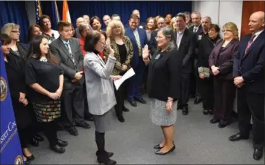  ?? PROVIDED ?? Adele Reiter, center right, is sworn in as acting Ulster County Executive on Monday at the the County Office Building in Kingston, N.Y., by County Clerk Nina Postupack as county department heads, commission­ers and others look on.