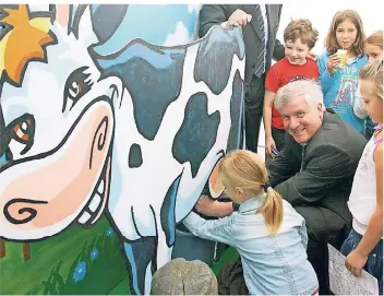  ?? ARCHIVFOTO: DPA ?? Da lacht die Kuh und der (damals Agrar-)Minister freut sich. Doch die Mutter aller Nahrungsmi­ttel hat inzwischen an Schulen einen schweren Stand.