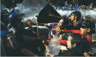  ?? REUTERSPIX ?? Protesters clash with anti-riot police officers as they try to march towards the US embassy during a rally in Manila yesterday.