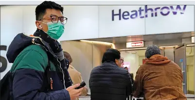 ??  ?? TAKING NO CHANCES: An airline passenger wearing a mask arrives at Heathrow’s Terminal 4 last week