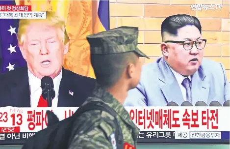  ??  ?? Un soldado surcoreano pasa en Seúl junto a una pantalla donde un noticiario anuncia la próxima reunión entre Donald Trump y Kim Jong-un.