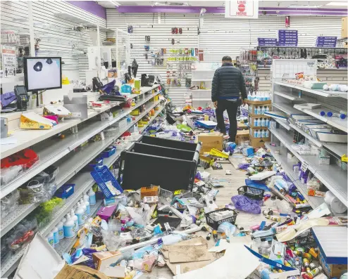  ?? Da vid ‘ Dee’ Delgado / REUTERS ?? A business owner walks in his looted beauty supply store Tuesday following protests over the fatal police shooting of 27-year- old Black man Walter Wallace in Philadelph­ia. Wallace was dealing with mental health issues, his family says.