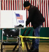  ??  ?? A voter ( left) marks his ballot in the first- in- the- nation presidenti­al primary in Nashua, New Hampshire, on Tuesday. Democratic presidenti­al candidate Hillary Clinton ( right) campaigns outside a polling station in Manchester, New Hampshire, on...