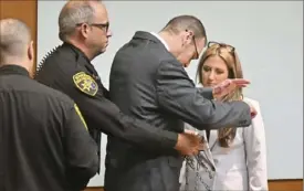  ?? Daniel Mears/Detroit News via AP ?? Oakland County Sheriff’s officers take the handcuffs and chains off James Crumbley, with attorney Mariell Lehman looking on, in the Oakland County Courtroom on Monday in Pontiac, Mich.