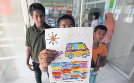  ?? CHUMPORN SANGVILERT ?? In this 2013 photo, a Rohingya boy shows his drawing at the Phangnga Shelter for Children and Families in Thailand.