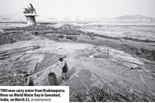  ?? AP/ANUPAM NATH ?? TWO men carry water from Brahmaputr­a River on World Water Day in Guwahati, India, on March 22.