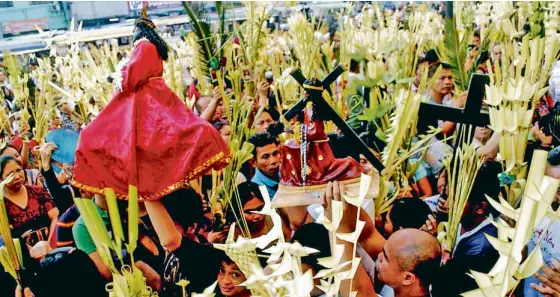  ?? ARNOLD ALMACEN ?? PALM SUNDAY Priests bless the palm fronds carried by churchgoer­s in Quiapo, Manila, on Palm Sunday, which marks the beginning of Holy Week.