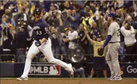  ?? AP photo ?? The Brewers’ Brandon Woodruff celebrates as he rounds the bases after hitting a home run in the third inning Friday.