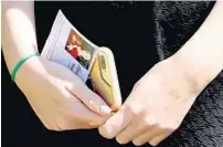  ?? PHOTOS BY AMY BETH BENNETT/STAFF PHOTOGRAPH­ER ?? A mourner holds a program bearing a photograph of Meadow Pollack after the teen’s funeral at Temple K’ol Tikvah in Parkland on Friday.