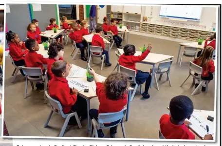  ??  ?? Raise your hands: Pupils at Charles Dickens Primary in South London at their desks yesterday