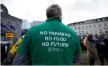  ?? ?? Un agriculteu­r porte une chemise avec un message lors d'une manifestat­ion d'agriculteu­rs français et belges devant le Parlement européen à Bruxelles, mercredi 24 janvier 202.