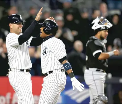  ??  ?? Former Cub Starlin Castro celebrates his three- run homer with Matt Holliday in the fifth inning at Yankee Stadium. | SETH WENIG/ AP